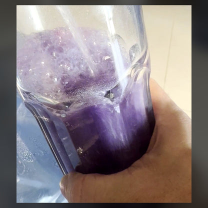 One scoop of CRACK3D Gurney Grape mixed with cold water in a glass — deep purple, fully dissolved